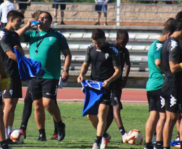 Javi Galán cogiendo un peto junto a Sandoval.