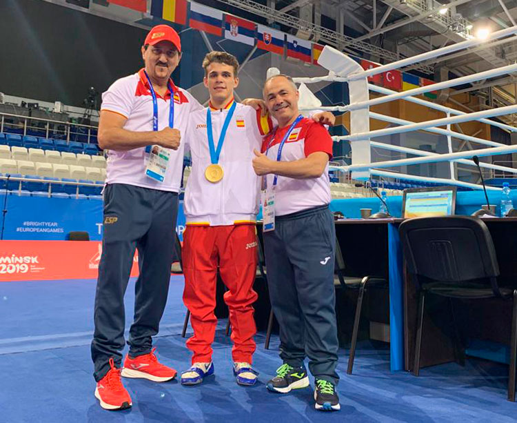 Rafa Lozano posando con Gabriel Escobar y su ayudante Antonio Peñate junto a un ring de los Juegos Europeos