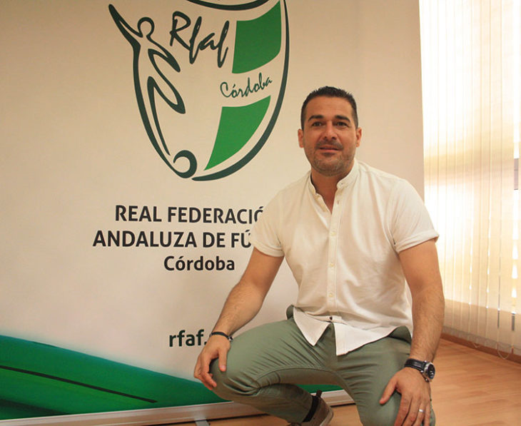 Pablo Lozano posando ante el cartel de la Andaluza en la delegación cordobesa