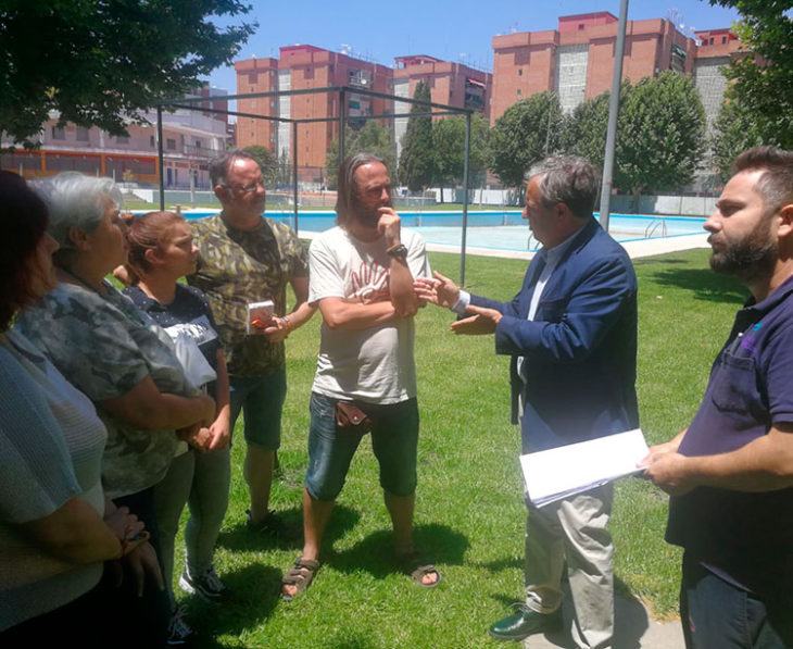 Salvador Fuentes departiendo con Javier Pérez, uno de los líderes del movimiento vecinal en la Fuensanta, sobre el césped de la piscina de la barriada