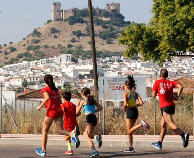 Varios atletas corriendo con el Castillo de Almodóvar Del Río al fondo.