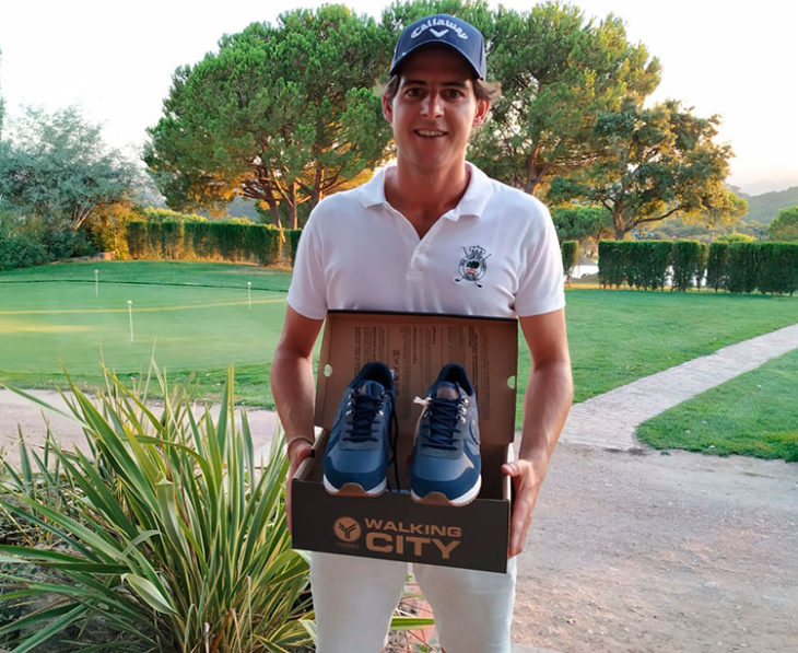 Lorenzo Ostos posando con los zapatos de golf que ganó con su triunfo en el P&P