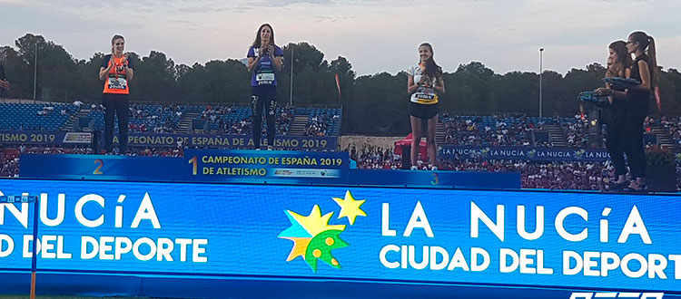 Carmen Romero aplaudiendo a sus compañeras de podio.