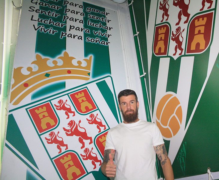 Chus Herrero ante el escudo del Córdoba en la bocana de vestuarios