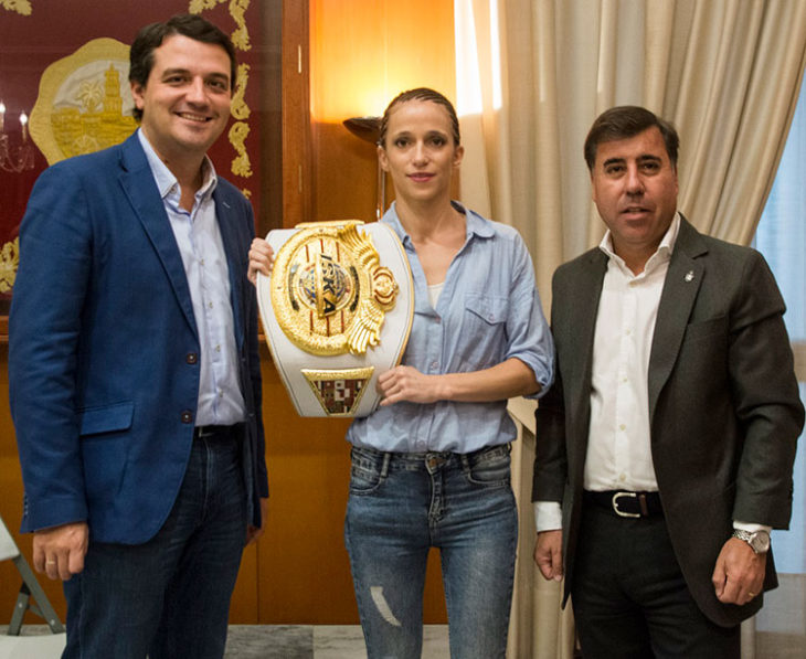 Cristina Morales muestra su cinturón de campeona del mundo entre José María Bellido y Miguel Ruiz
