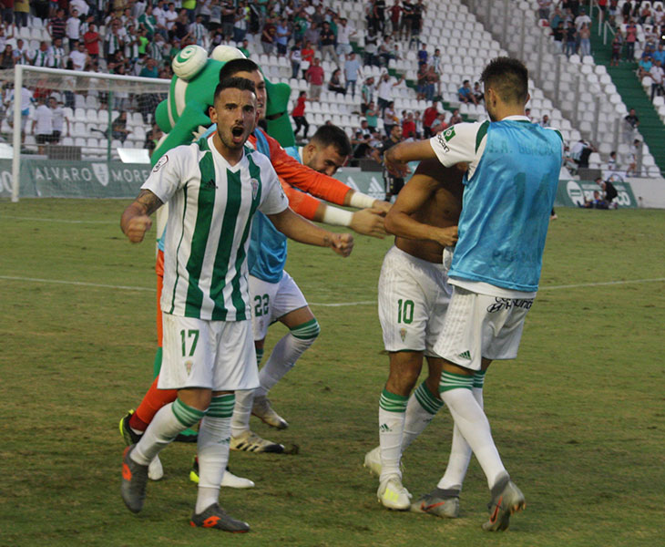 Fernández celebrando el gol con la afición mientras Miguel de las Cuevas se recomponía de la piña que formaron los blanquiverdes
