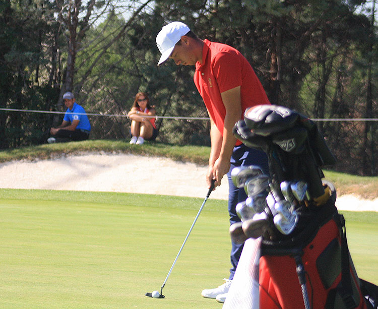Víctor Pastor en el green del 15 con su entrenador, Iván Pastor, y su madre al fondo