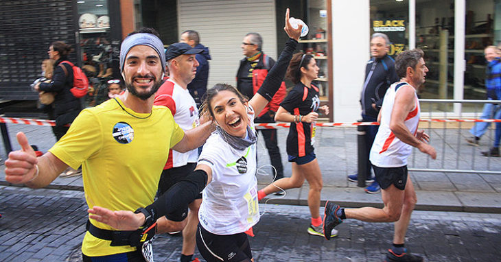Una pareja muestra su alegría corriendo la Media Maratón 2019 a su paso por Gondomar