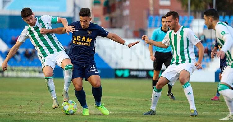 Javi Flores forcejeando con un jugador del UCAM Murcia con Imano García y Víctor Ruiz a la derecha