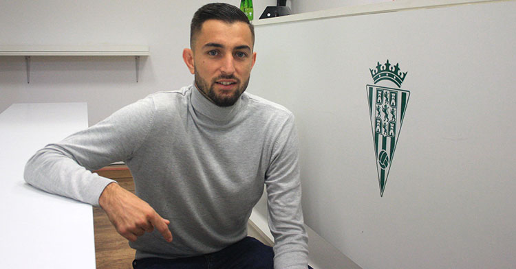 José Antonio González posando junto al escudo del Córdoba CF
