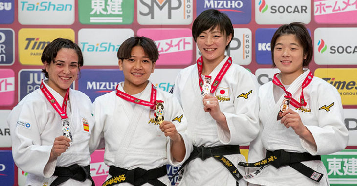 Julia Figueroa, a la izquierda, mostrando su medalla de plata rodeada de japonesas