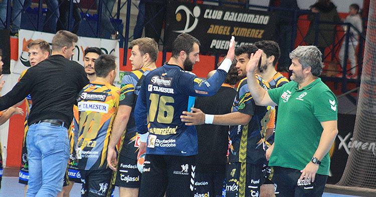 Paco Bustos estrecha su mano al aire con el meta bosnio Adi, entre la satisfacción generalizada del plantel tras derrotar al Cangas