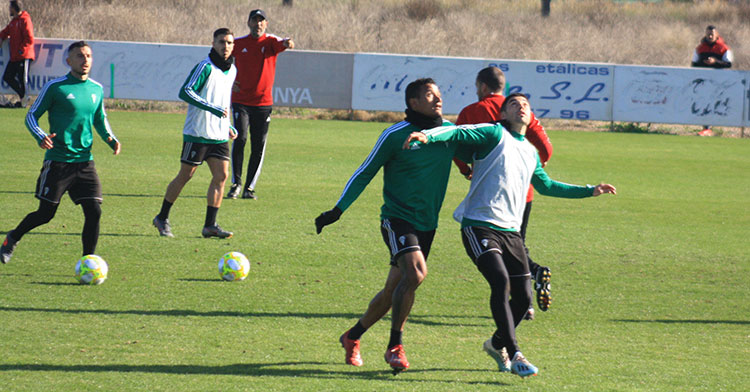 Luis Garrido pugna con Jesús Álvaro por la posición ante un balón aéreo con Raúl Agné al fondo.