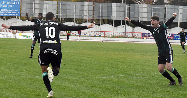 Javi Flores alza sus brazos para celebrar el gol de Miguel de las Cuevas que sale a la carrera