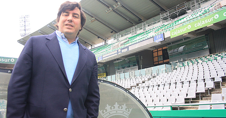 Jesús Coca posa junto al banquillo con el escudo del Córdoba y el palco de fondo