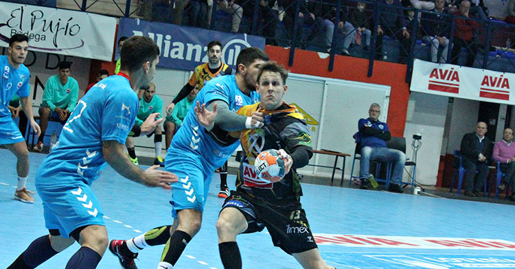 Víctor Alonso intenta penetrar ante dos jugadores del Sinfín