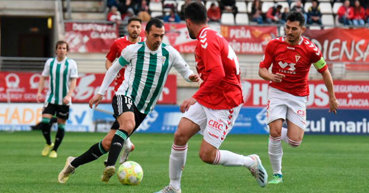 Miguel de las Cuevas en un eslalom entre jugadores del Real Murcia.