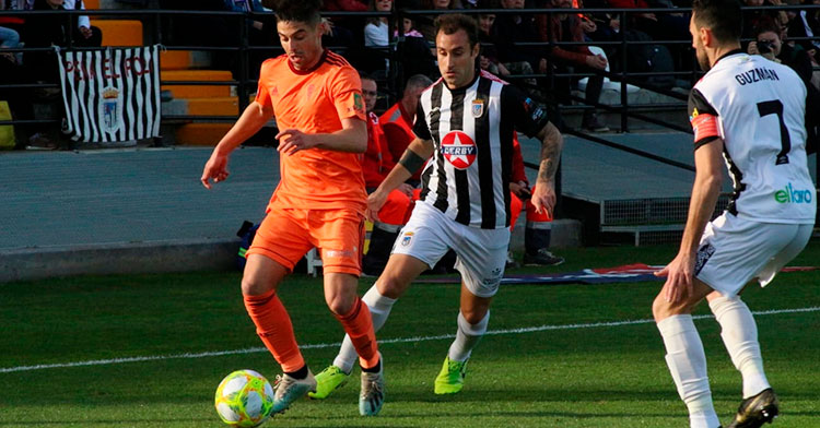 Jesús Álvaro avanzando con el balón ante dos jugadores del CD Badajoz.