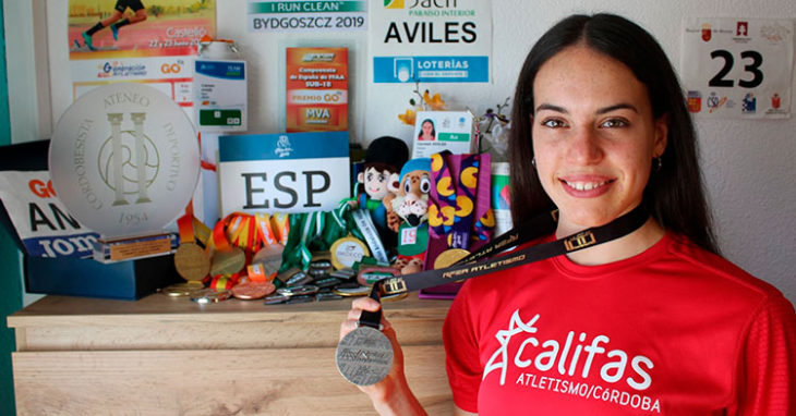 Carmen Avilés posando con su presa de plata absoluta y todo su medallero de fondo ya de vuelta en su casa.