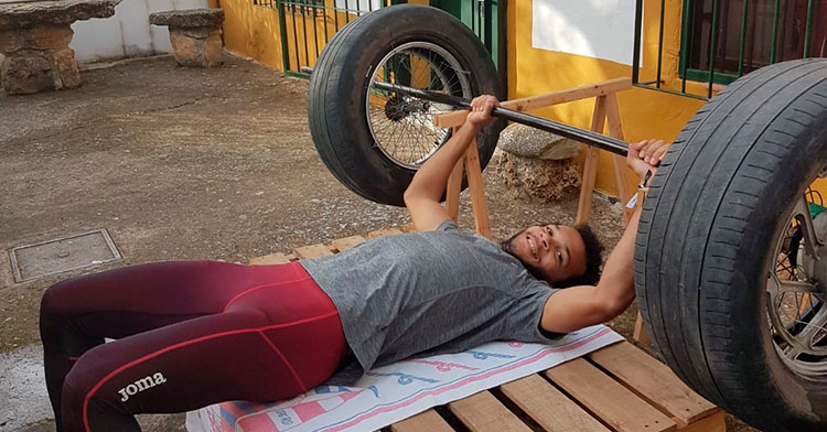 José Luis Fernández probando sus particulares pesas con neumáticos usados de su abuelo.