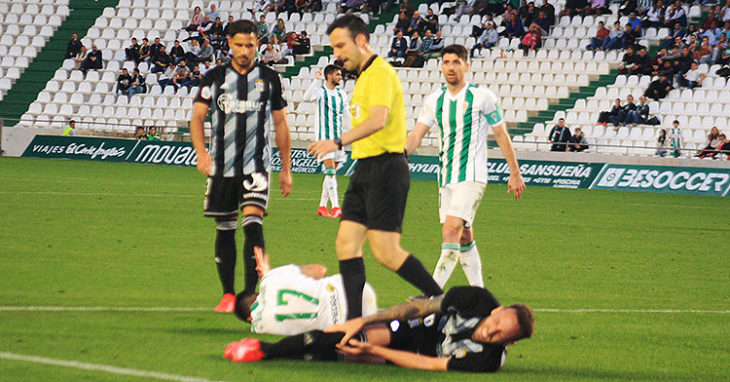 Javi Flores junto a un jugador del Cartagena observan a sus compañeros doloriéndose sobre el césped.