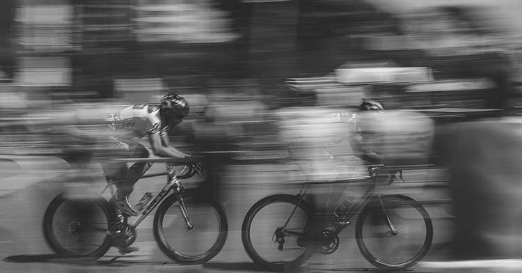 Dos ciclistas pedaleando a gran velocidad en un descenso