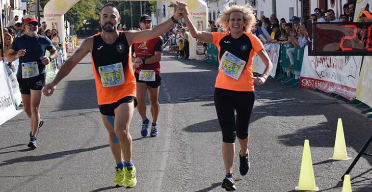 Una pareja de atletas populares cruzando la línea de meta de la Media Maratón de Almodóvar del Río.