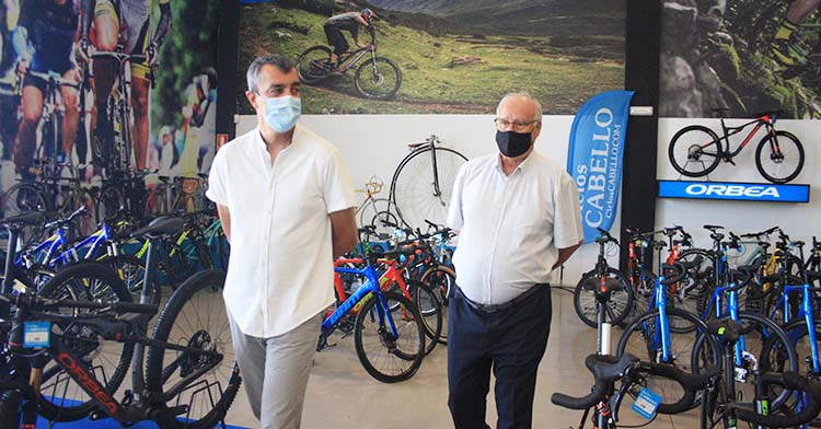 Antonio Cabello junto al director general de la Vuelta a España rodeado de bicicletas.