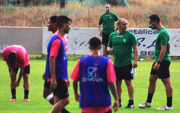 Sabas departiendo con Rubén Bretones ante varios de sus jugadores, con Javi Poveda al fondo.