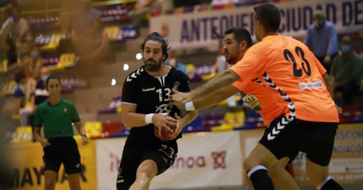 Vicente Poveda intenta penetrar ante dos jugadores de Antequera.