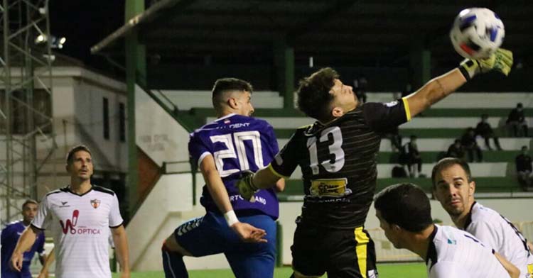 El meta del CD Pozoblanco Javi de la Fuente intenta despejar de puños ante el delantero del Puertollano. Autor: Cspuertollano.com