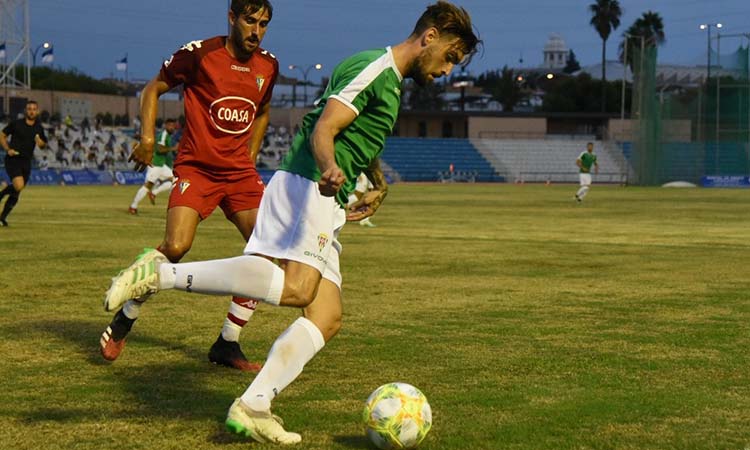 Samu Delgado protege el balón ante la llegada de un jugador del San Fernando.