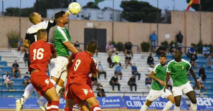 El meta del San Fernando Perales se adelanta a Willy para despejar con su puño.