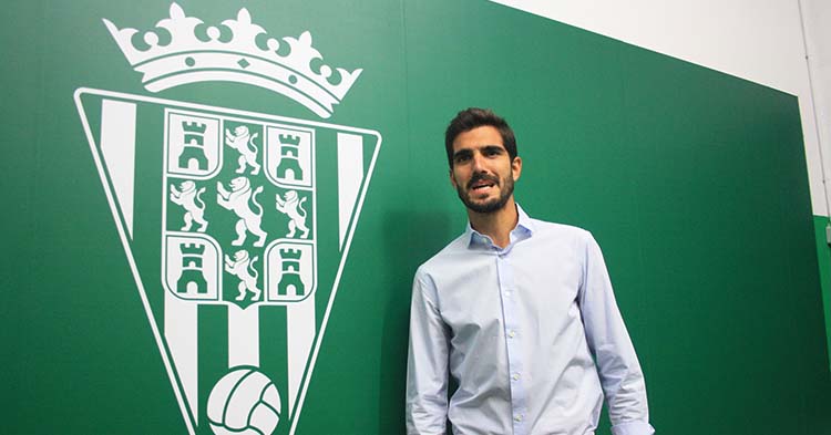Bernardo Cruz posando junto al escudo del Córdoba CF.