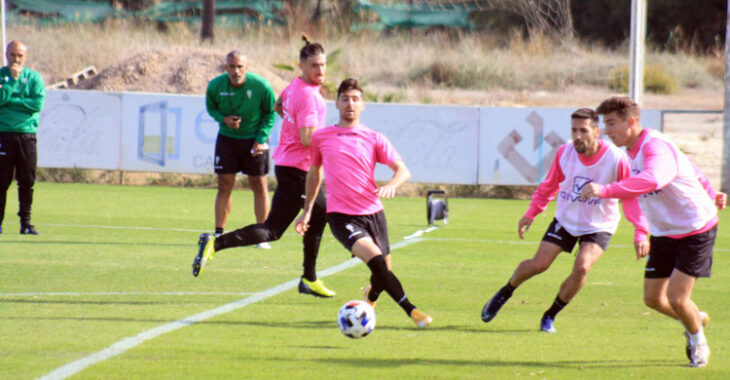 Alberto Del Moral busca el balón ante Javi Flores, con Samu Delgado y Carlos Valverde en segundo plano, mientras Manu Robles y Sabas siguen el entrenamiento al fondo.