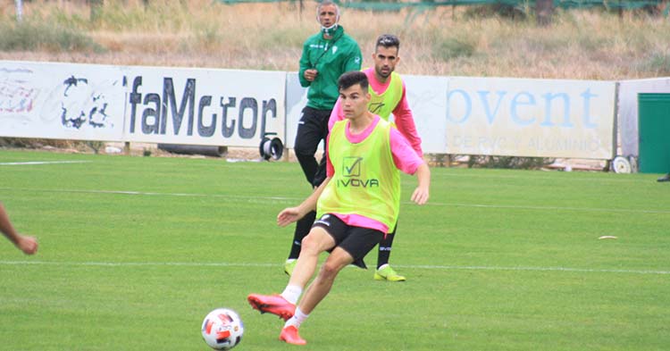 Luismi pasa el balón con Alain Oyarzun y Manu Robles al fondo.