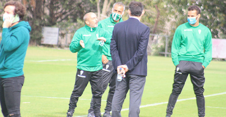 Raúl Cámara habla por el móvil mientras Sabas gesticula al fondo ante Javier González Calvo y varios componentes del cuerpo técnico.