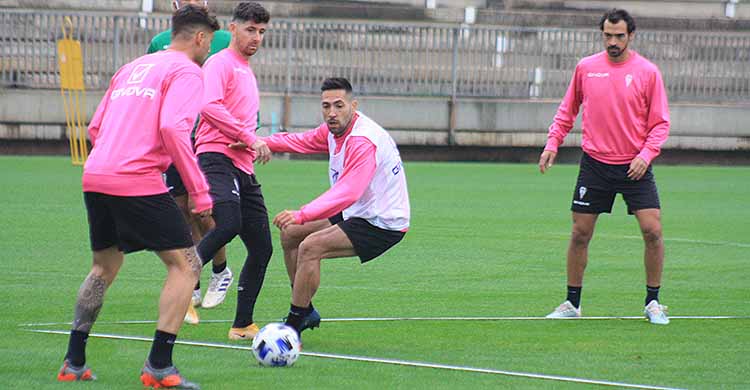 Carlos Valverde busca el balón ante Javi Flores y Xavi Molina con Miguel de las Cuevas al fondo.