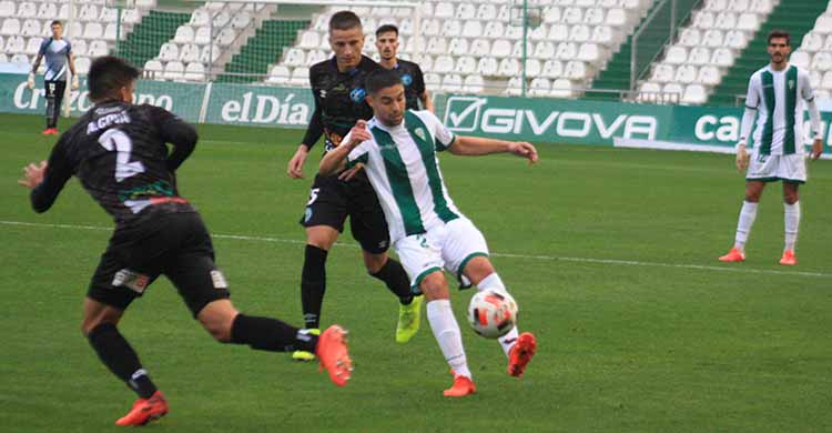 Jesús Álvaro pasa el balón entre dos jugadores de El Ejido.