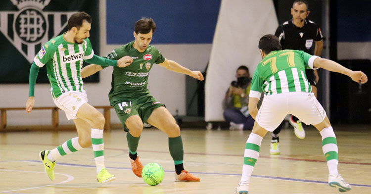 Pablo del Moral con el balón ante dos defensores béticos
