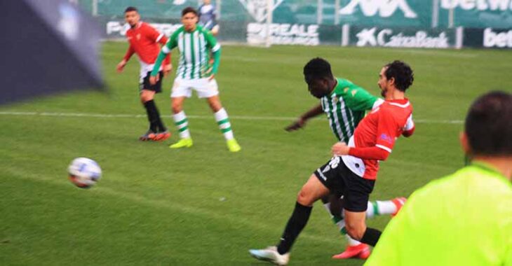Miguel de las Cuevas intenta meter el cuerpo ante un bético bajo la granizada que cayó en los minutos finales del partido.Miguel de las Cuevas intenta meter el cuerpo ante un bético bajo la granizada que cayó en los minutos finales del partido.