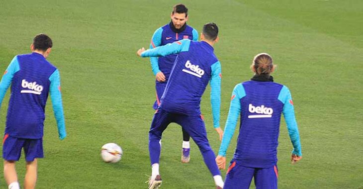Messi pasa el balón ante la llegada de Sergio Busquets.