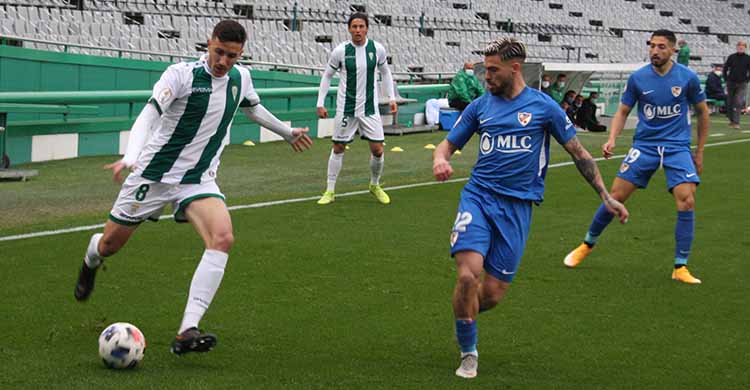 Alberto Ródenas busca el centro ante un jugador el Linares.