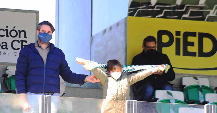 Un joven cordobesista mostrando la bufanda del Córdoba CF junto a su padre.