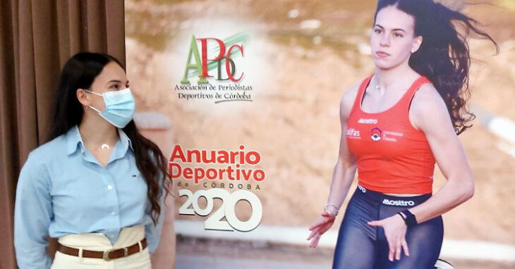 Carmen Avilés mirando al póster que emula la portada del Anuario 2020, con ella como protagonista