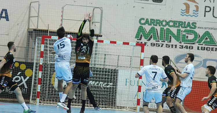 Javi García intenta blocar un lanzamiento de un jugador del Cangas.