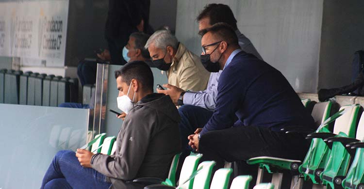 Juanito en primer plano con el nuevo técnico del filial, David Ortega, a sus espaldas, con Rafa Herrerías y Miguel Valenzuela al fondo igualmente centrados en sus móviles.