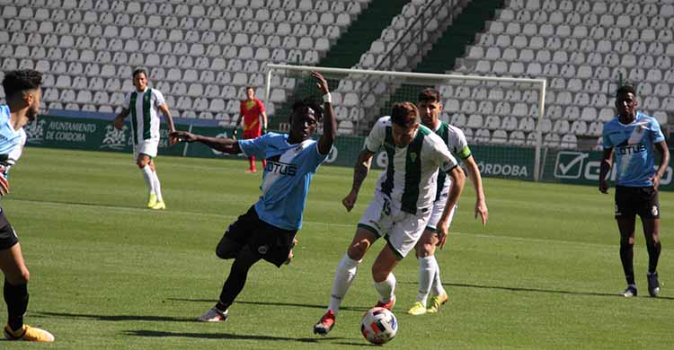 Nahuel Arroyo dejando atrás a un jugador del Linense con Javi Flores al fondo.