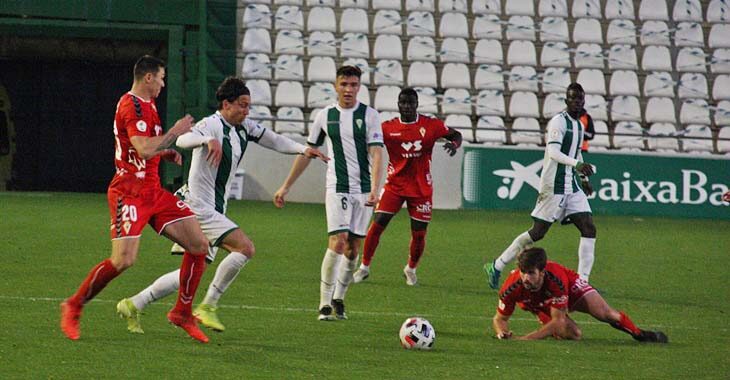 Adrián Fuentes, con el dorsal 20, encimando a Farrando en El Arcángel durante el partido ante el Real Murcia.