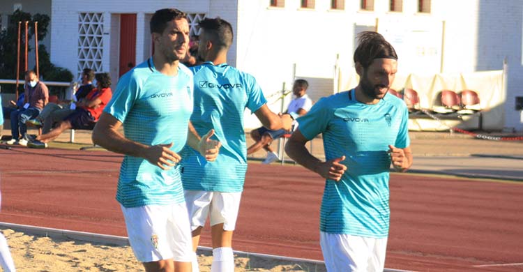 Toni Arranz calentando en la banda del Antonio Gil de Punta Umbría con Álex Bernal por delante.